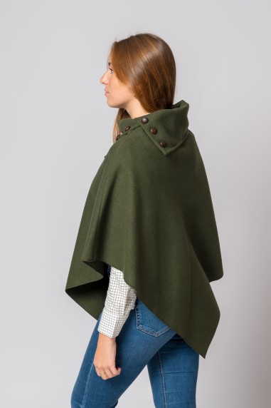Mulher de lado a usar capa poncho verde-oliva com botões castanhos no colarinho