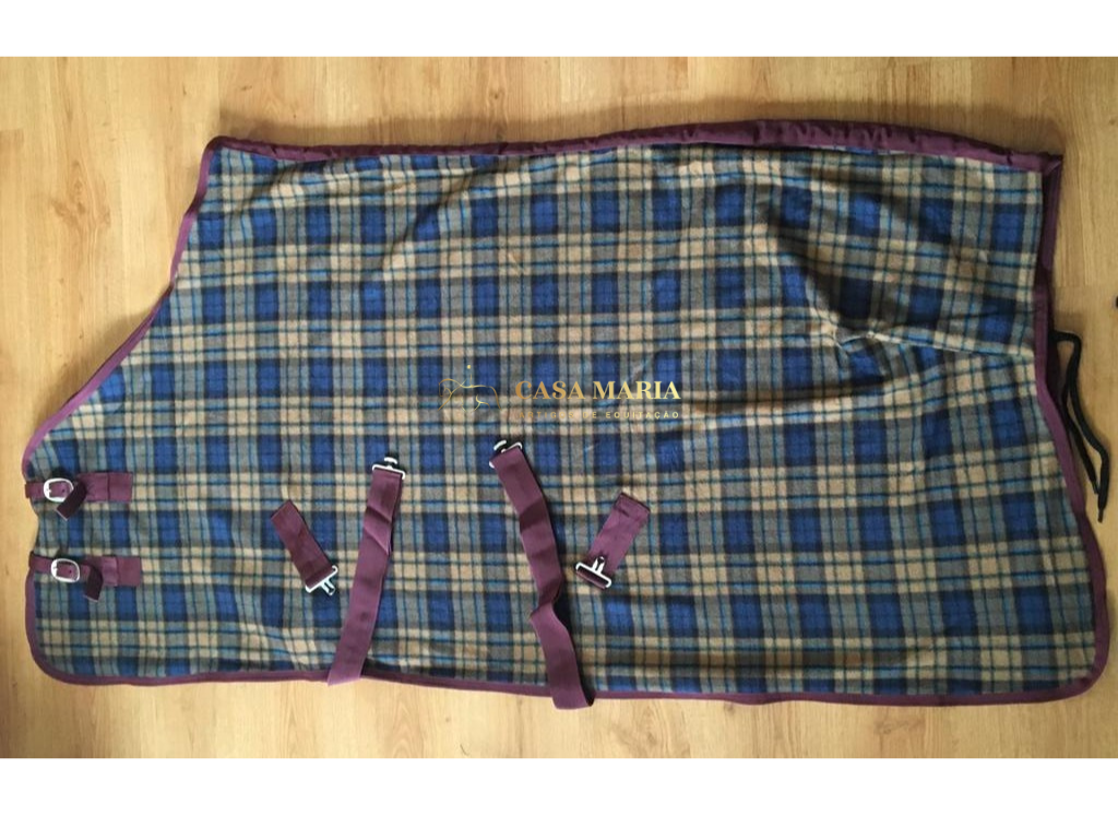 Manta para cavalo xadrez azul e bege com cintos roxos em chão de madeira