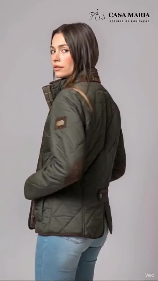 Mulher de perfil a usar casaco acolchoado verde-escuro com detalhes castanhos.
