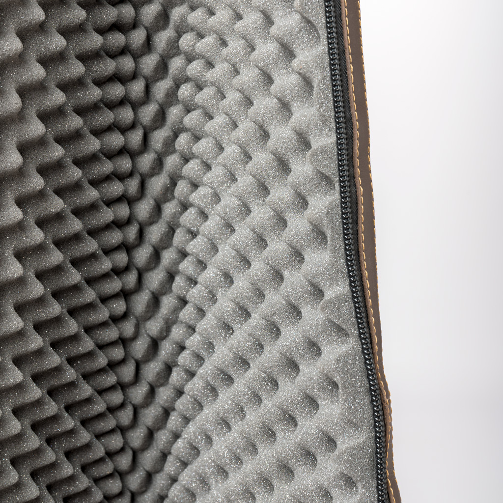 Interior de bolsa com espuma cinzenta ondulada e fecho preto.