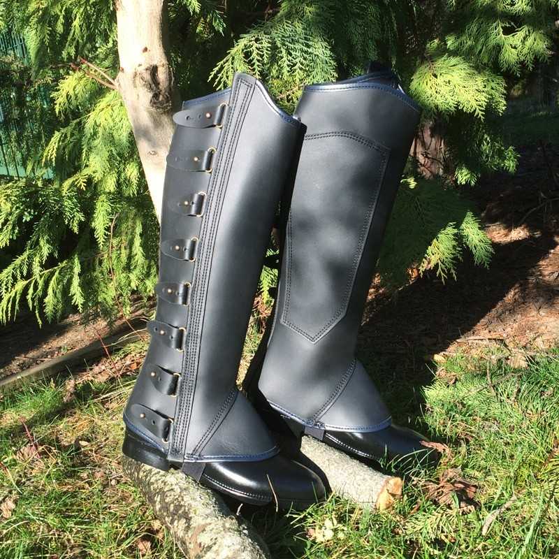 Botas pretas altas com fivelas e costuras em ambiente natural