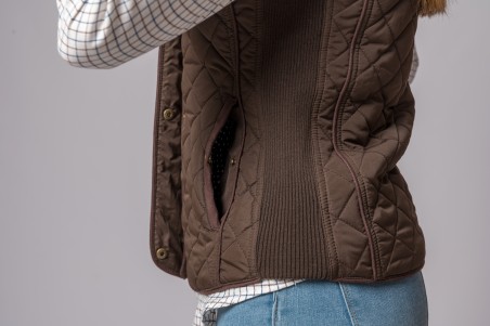 Colete castanho acolchoado com camisa branca às riscas e calças de ganga