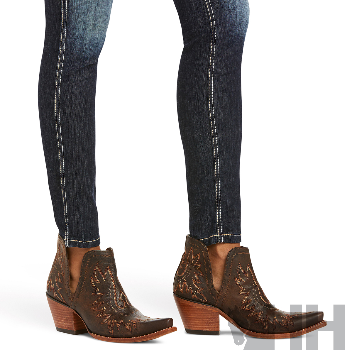 Botas de cowboy castanhas com bordados e jeans escuros