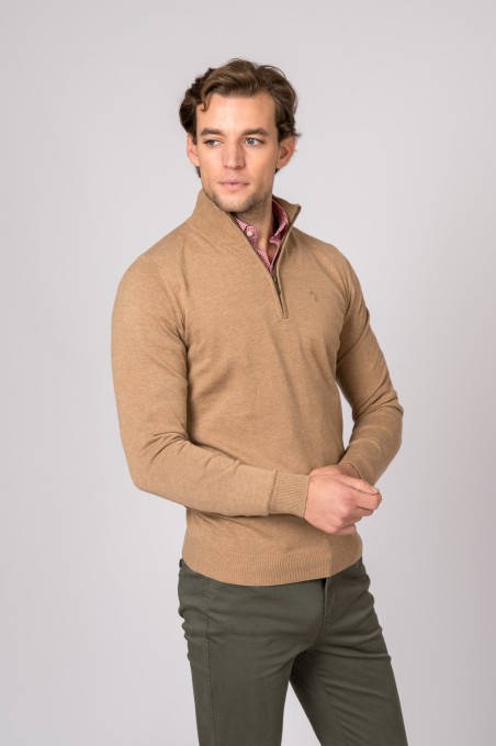 Homem com camisola bege de malha com fecho e calças verdes