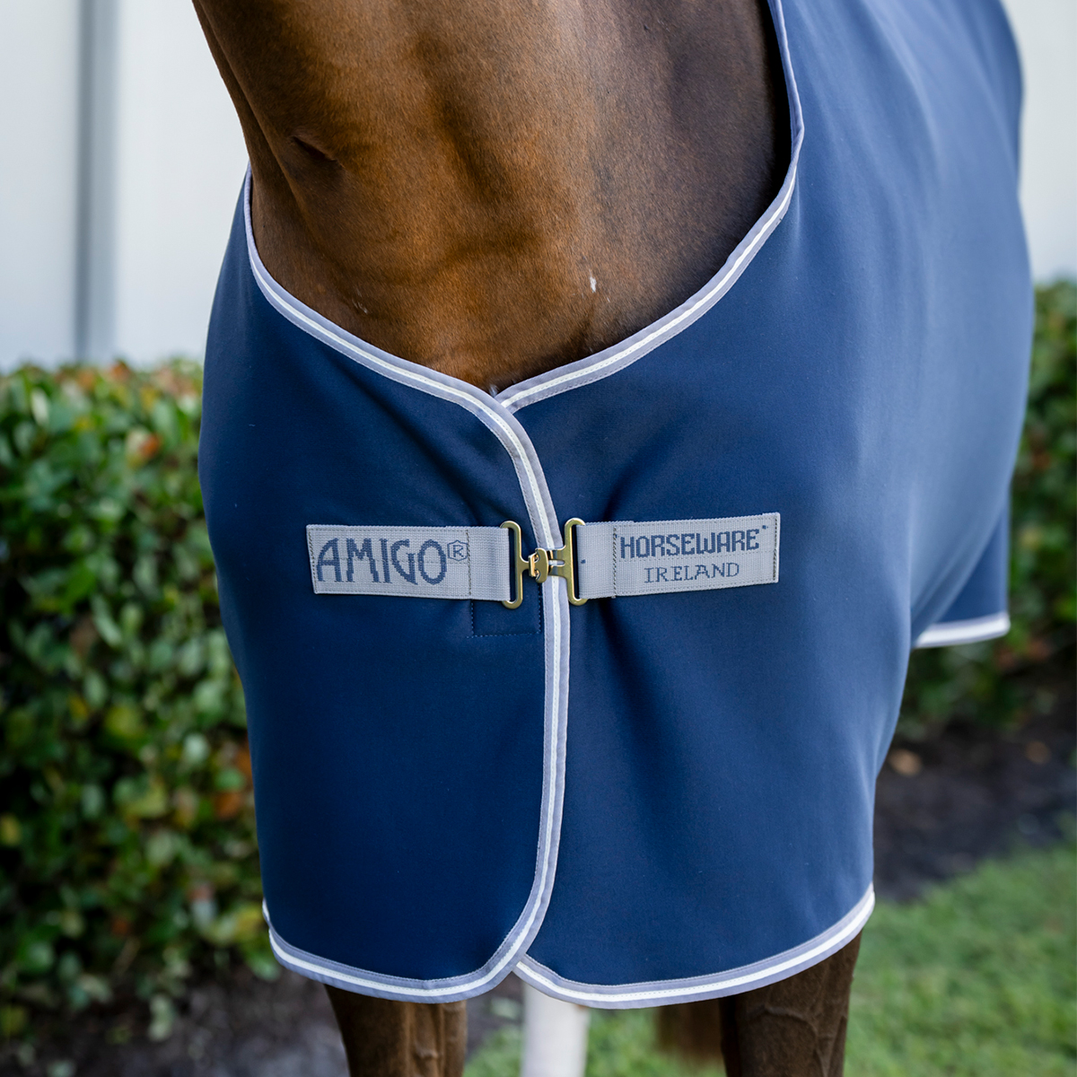 Cobertor azul para cavalo com bordas brancas e etiquetas visíveis