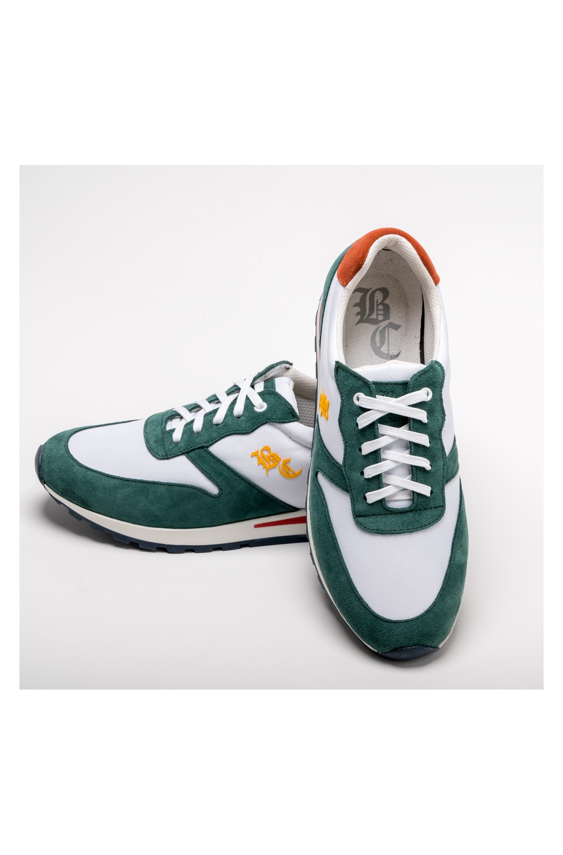 Par de sapatilhas desportivas branco e verde com detalhes laranja e amarelo