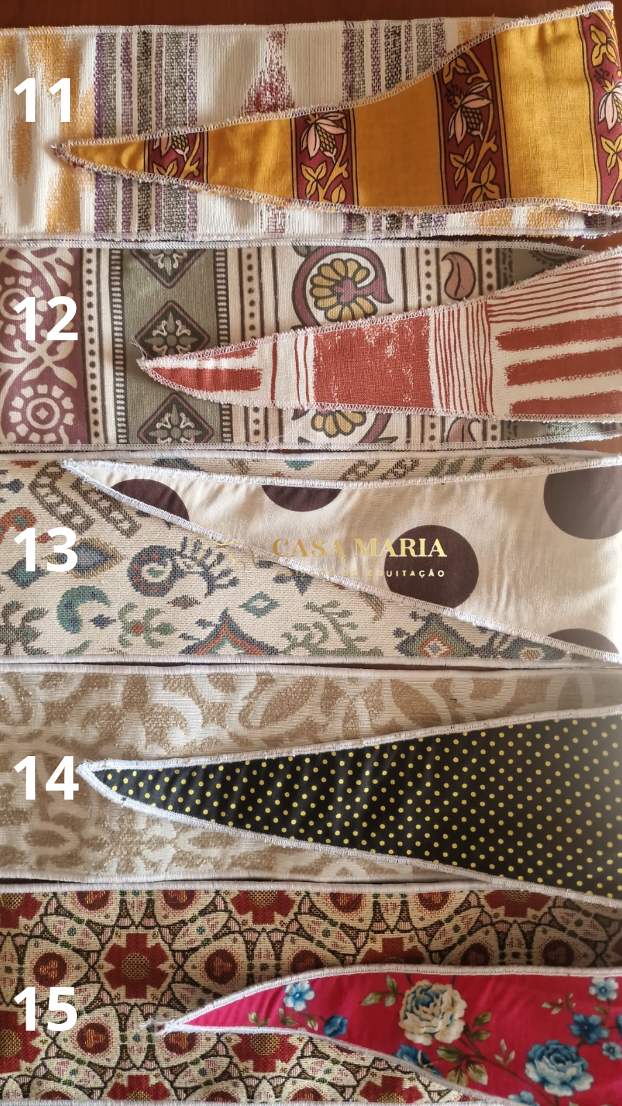 Cinco lenços triangulares variados com diferentes padrões e cores numerados de 11 a 15.