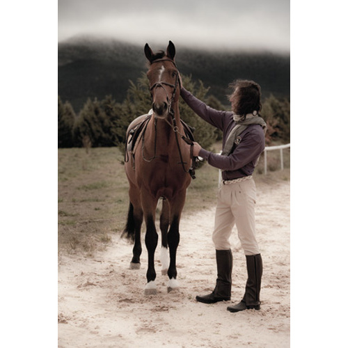 Homem vestido para equitação com cavalo castanho ao ar livre