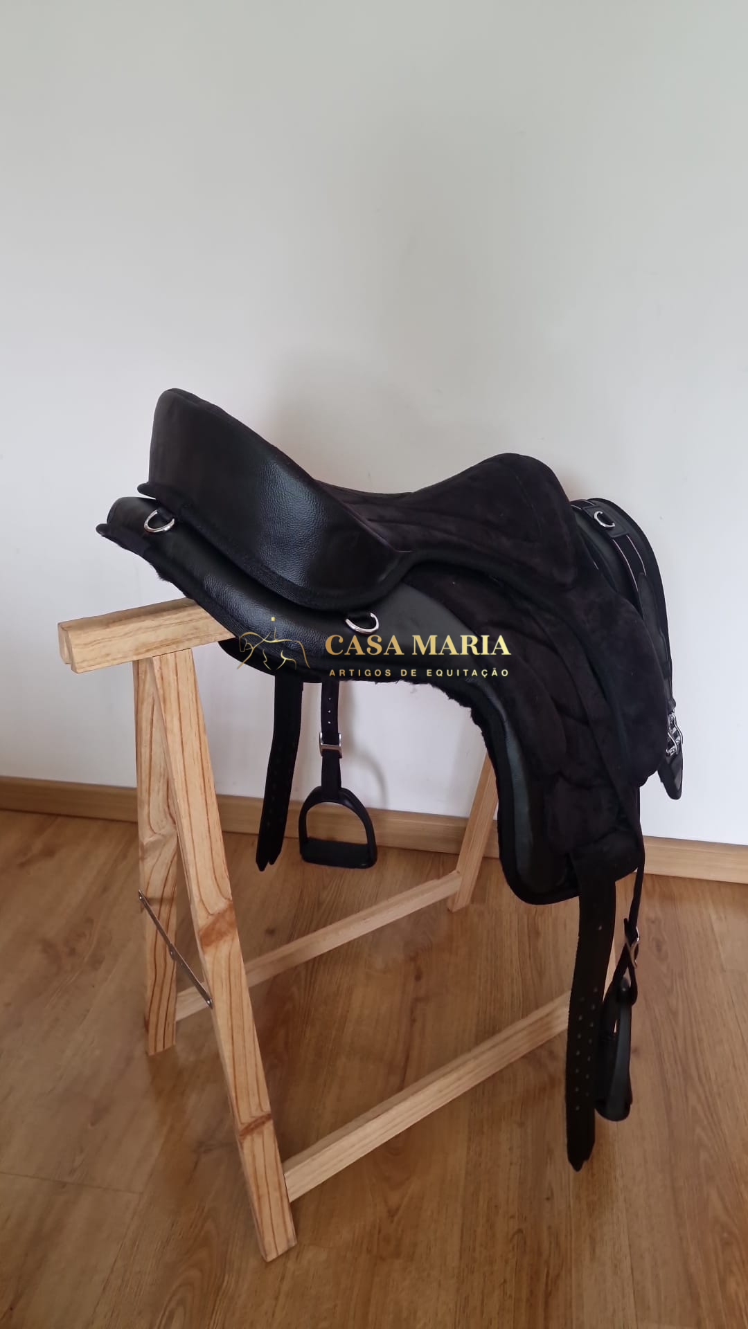 Selim de equitação preto em couro e camurça num suporte de madeira