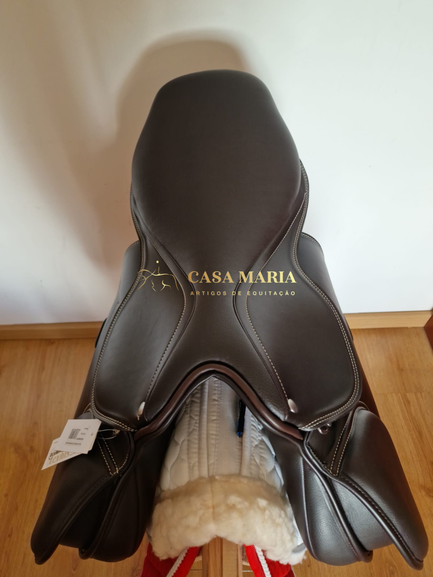Sela de equitação de couro castanho escuro com costuras brancas