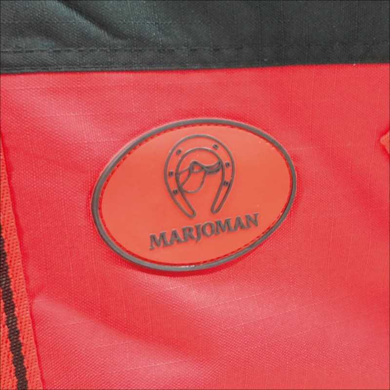 Etiqueta vermelha com texto MARJOMAN em tecido vermelho e preto