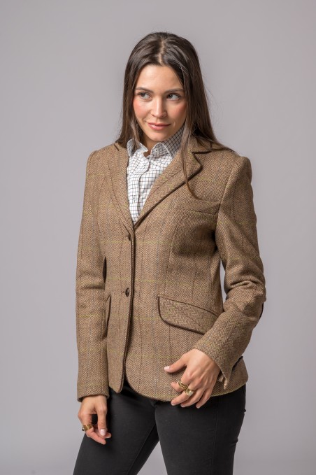 Mulher com blazer castanho xadrez, camisa quadriculada branca e calças pretas