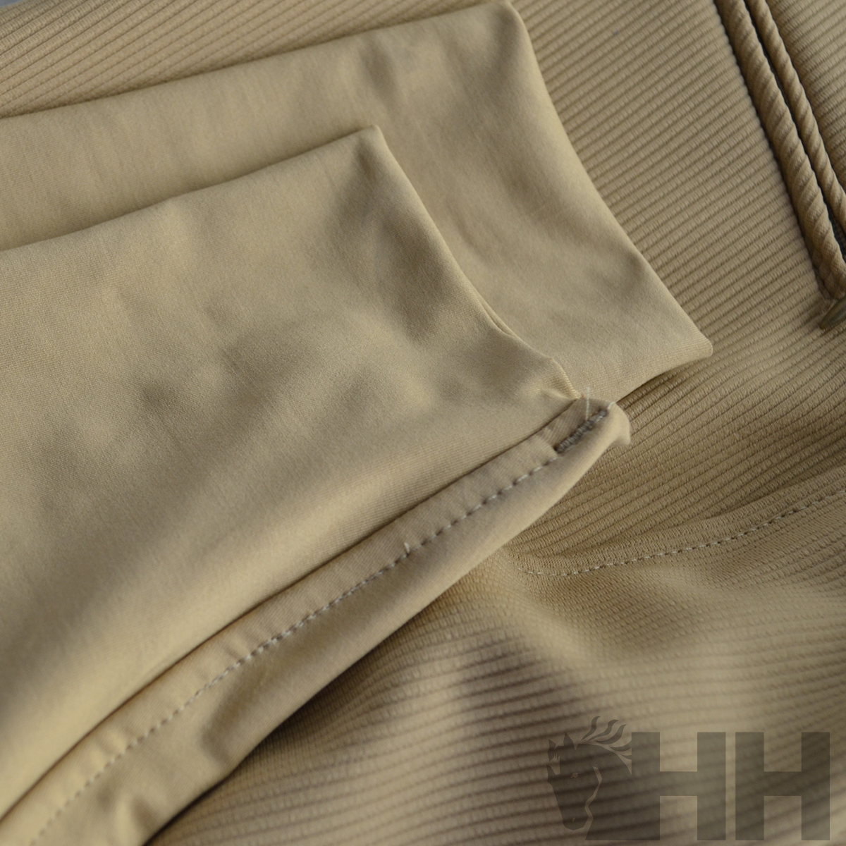 Tecido bege com texturas lisas e caneladas e costura visível