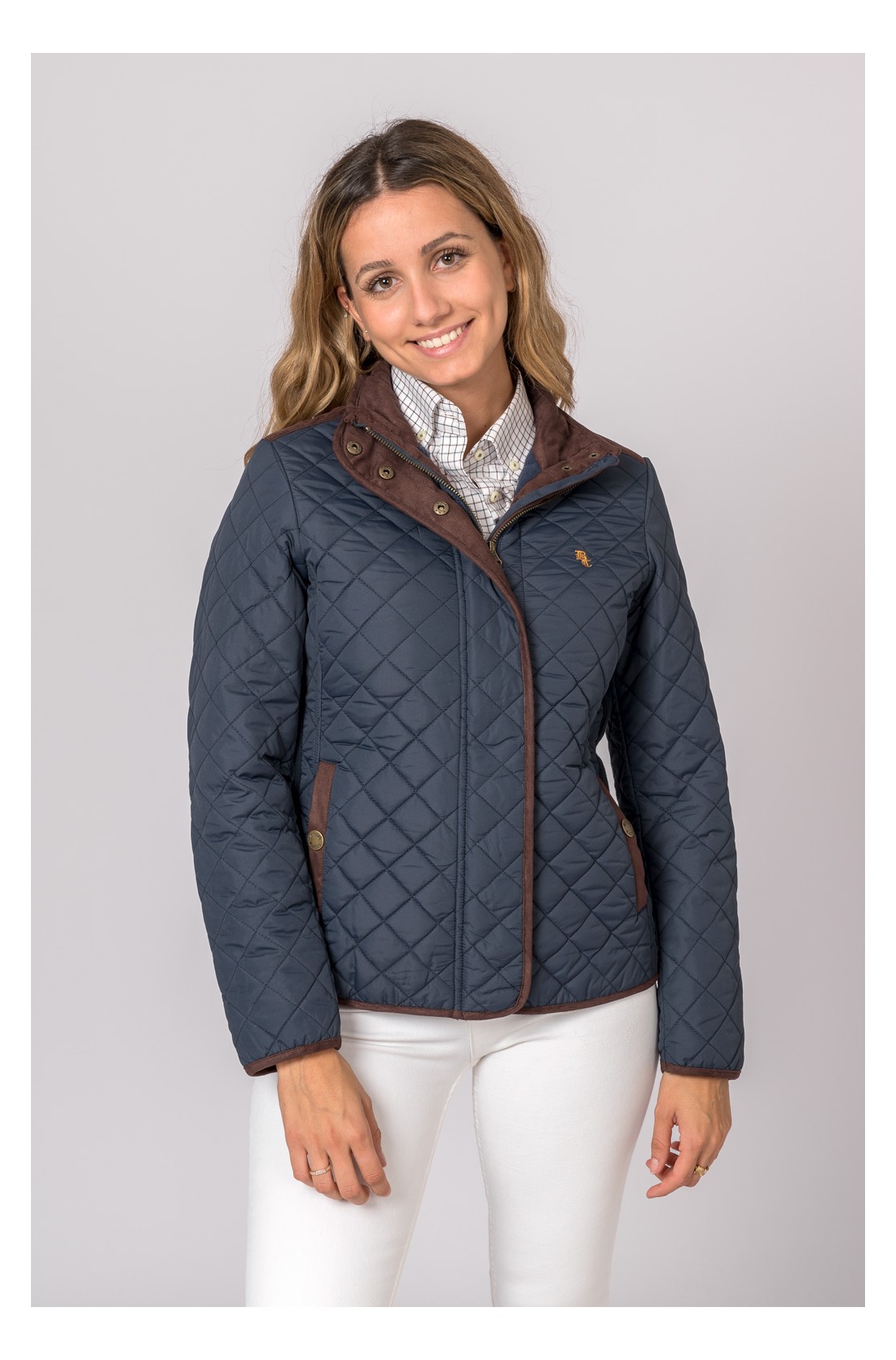 Mulher com casaco acolchoado azul escuro com detalhes castanhos