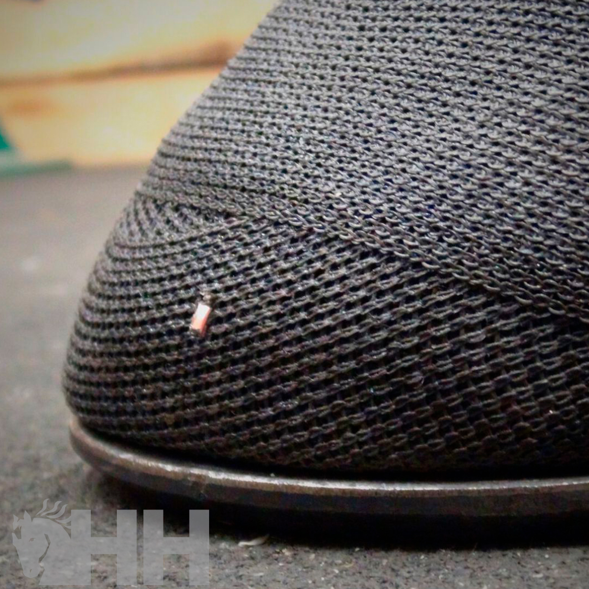 Calçado com tecido malha preto e sola preta visto de perto.