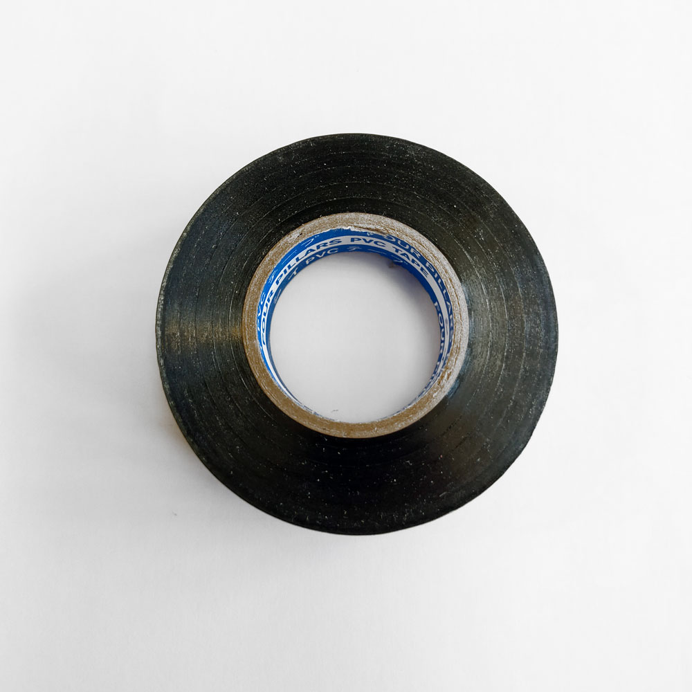 Rolo de fita isolante preta em PVC com interior de cartão e texto azul e branco