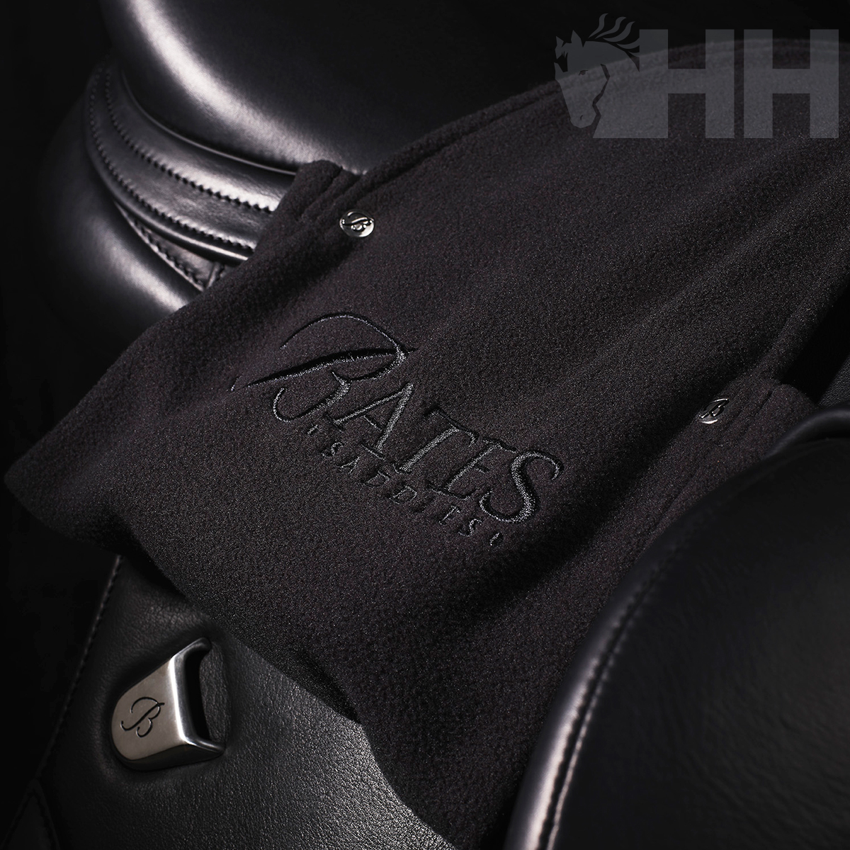 Tecido preto com bordado PALES SADDLERY sobre sela de couro preta