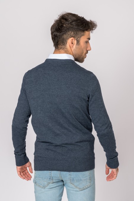 Homem de costas a usar camisola de malha azul escura e calças de ganga claras