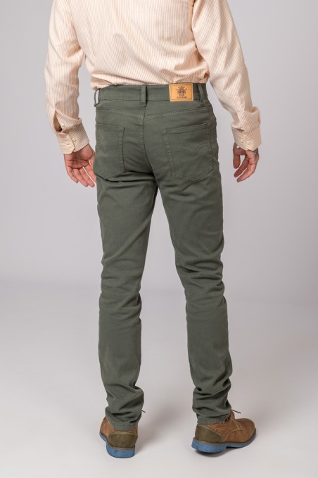 Calças de ganga verdes de costas com etiqueta de couro e camisa bege