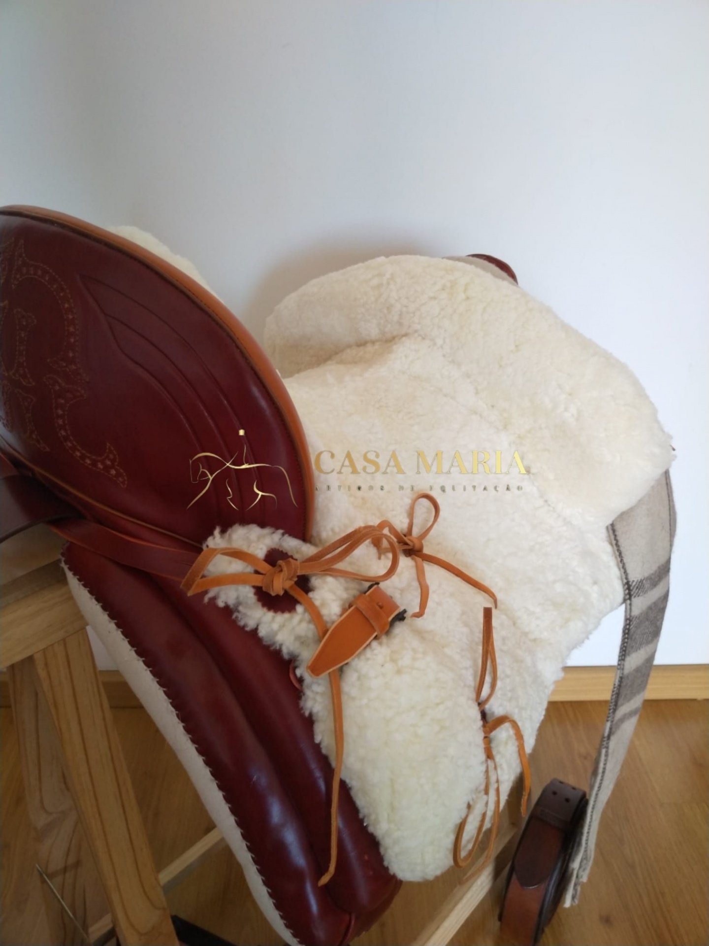 Sela castanha em couro com estofamento branco de lã e tiras em tecido xadrez