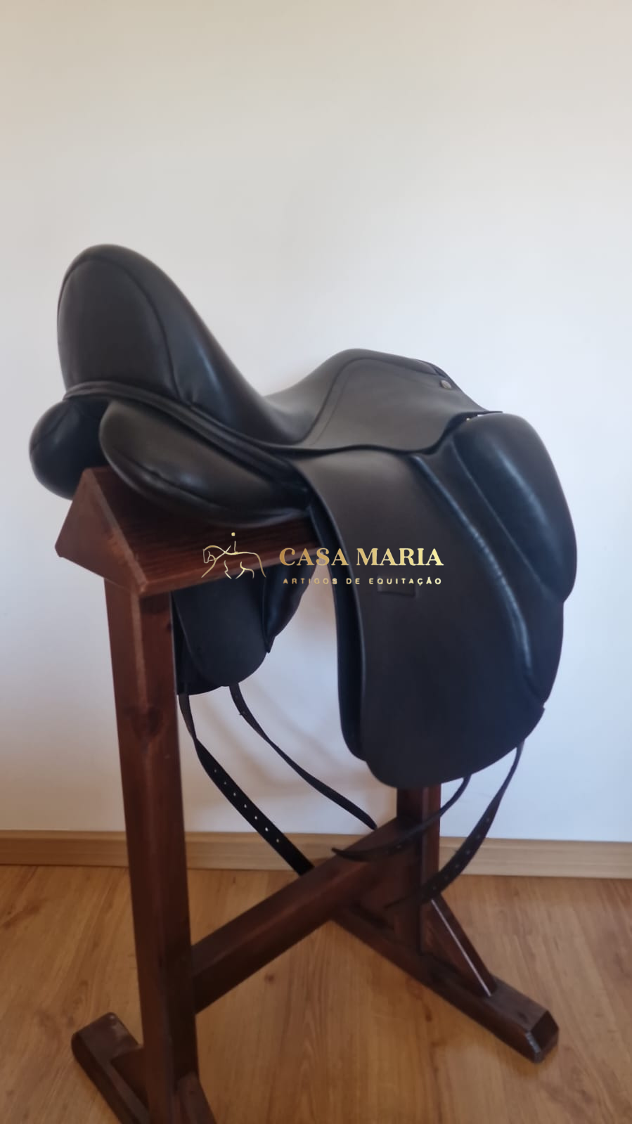 Sela de equitação preta em pele numa estrutura de madeira