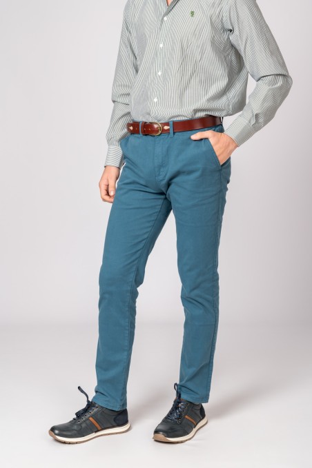 Homem com camisa de riscas, calças azuis, cinto castanho e sapatos desportivos pretos