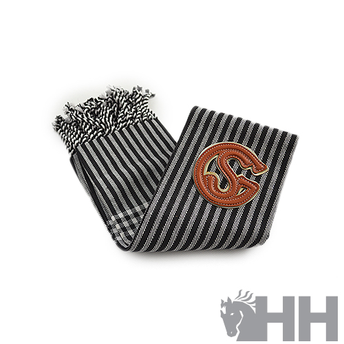 Cachecol listrado em preto, branco e cinzento com franjas e emblema castanho