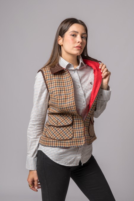 Mulher com camisa xadrez branca e colete xadrez castanho com interior vermelho aberto