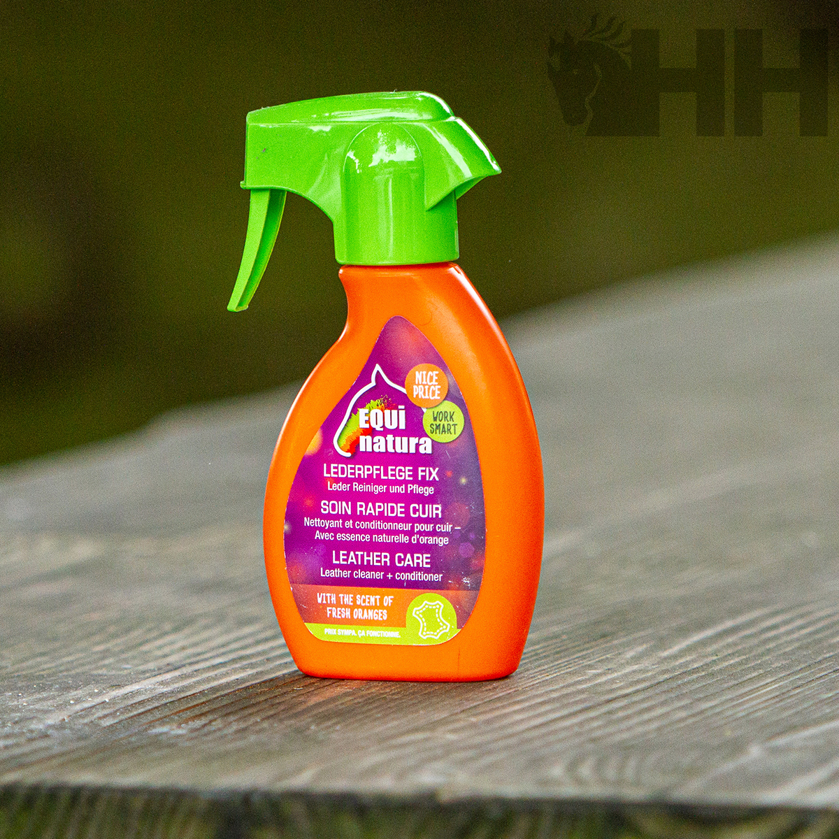 Frasco de spray laranja e verde para cuidado de couro numa superfície de madeira