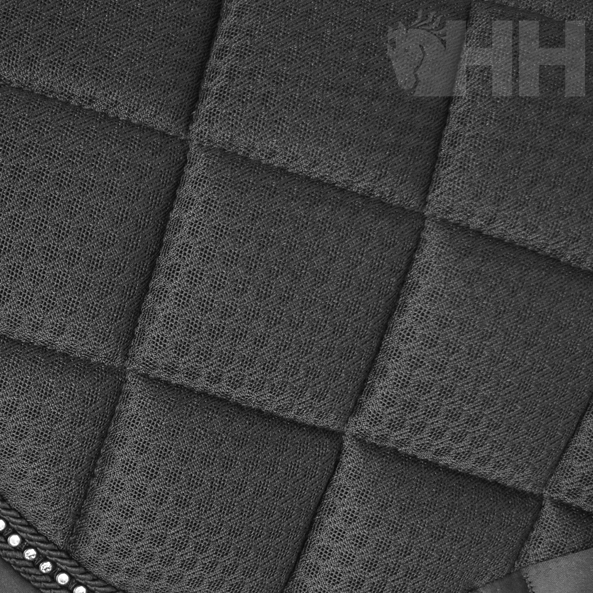 Tecido preto acolchoado em padrão quadrado com textura em rede e tachas metálicas prateadas.