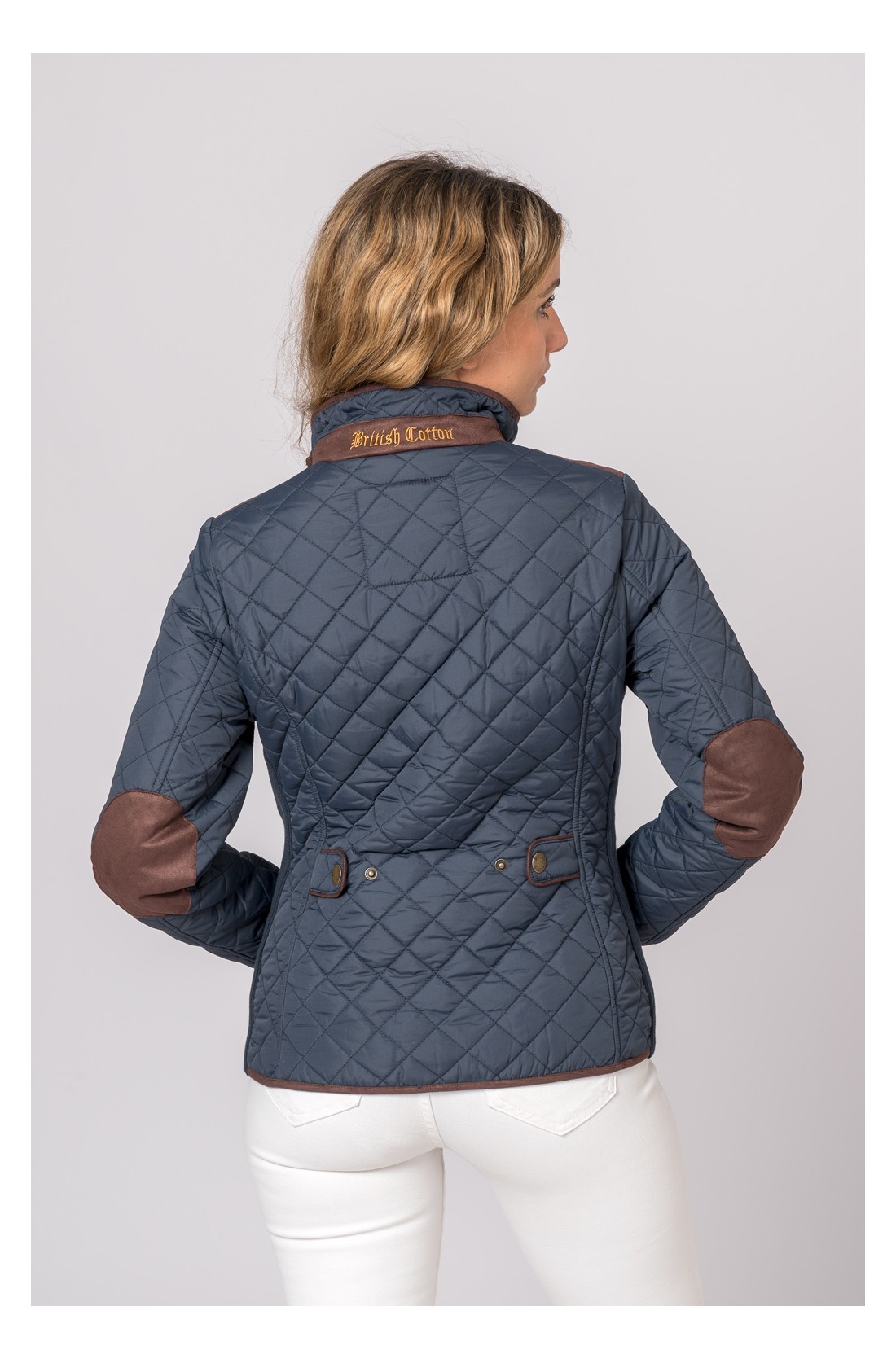 Casaco azul escuro matelassado com detalhes castanhos e texto British Outdoor no colarinho