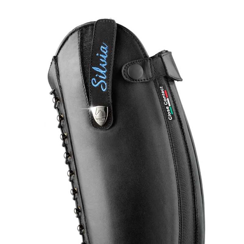 Perneira preta de pele com fecho de correr e inscrição 'Sílvia'