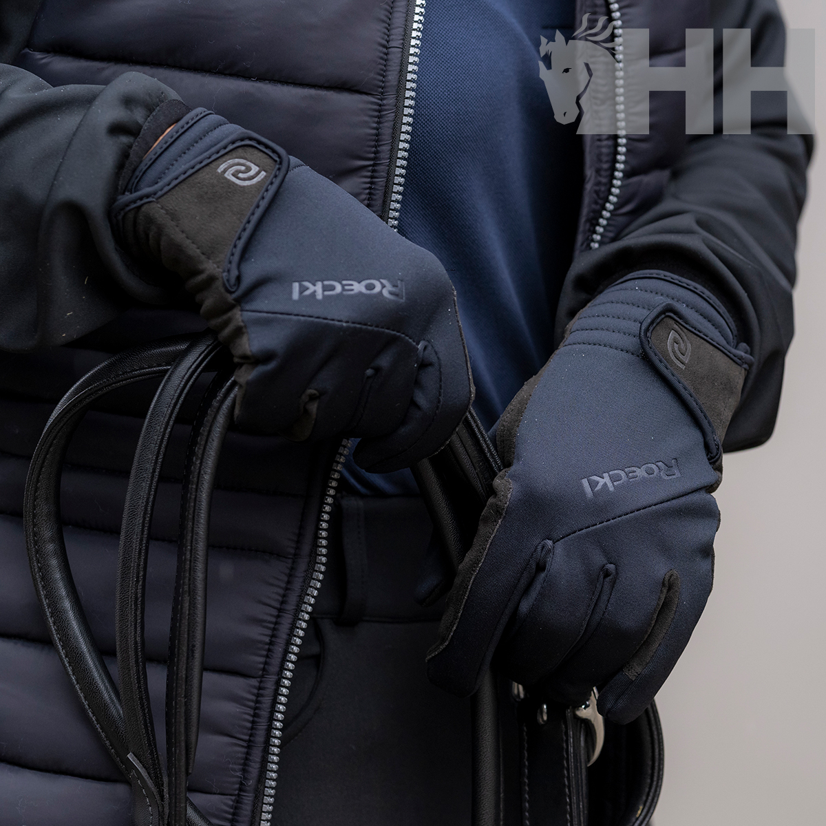 Luvas pretas ROECKL em mãos segurando cabos pretos