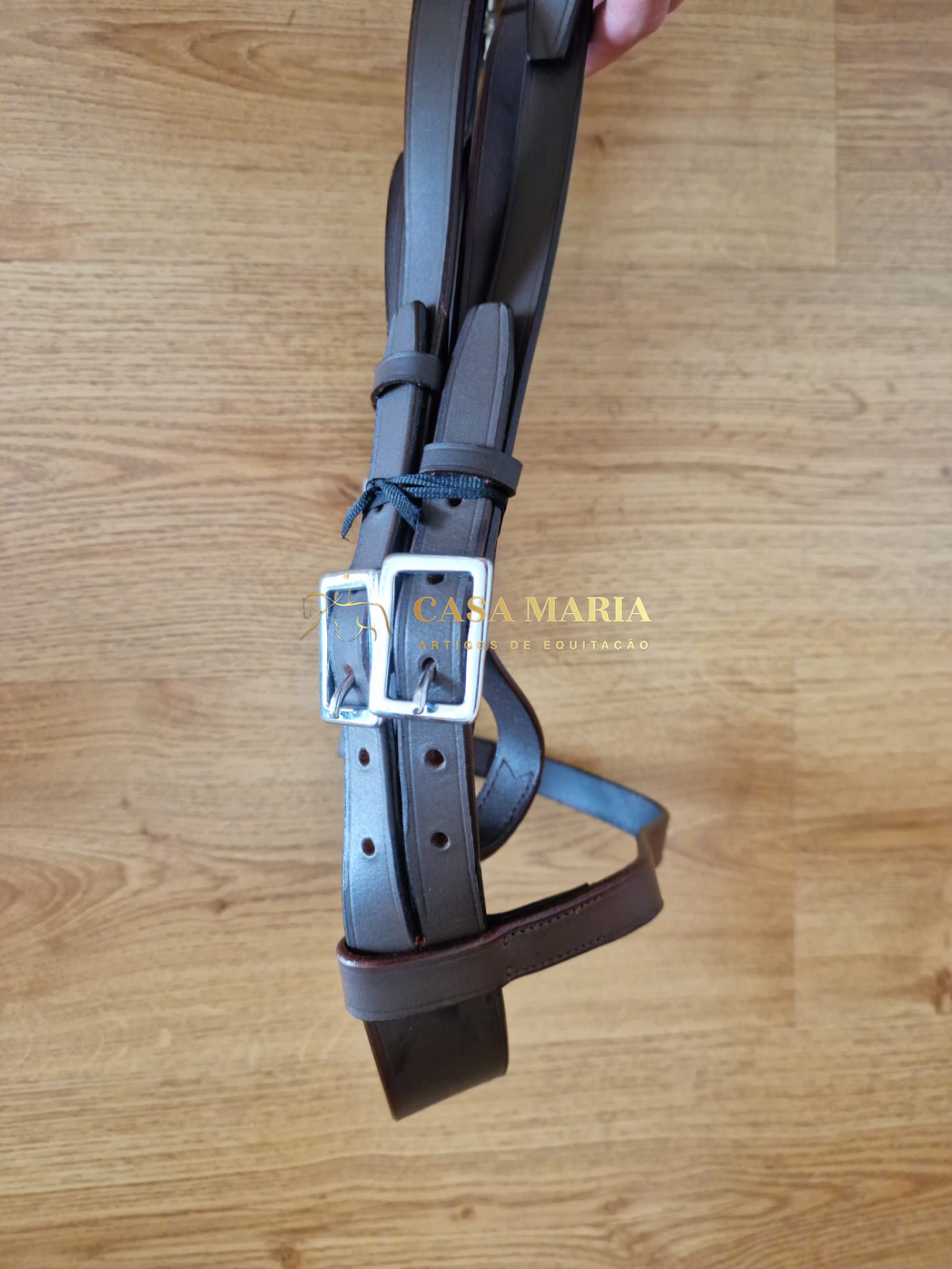 Correia de couro castanho com fivelas metálicas e texto Casa Maria