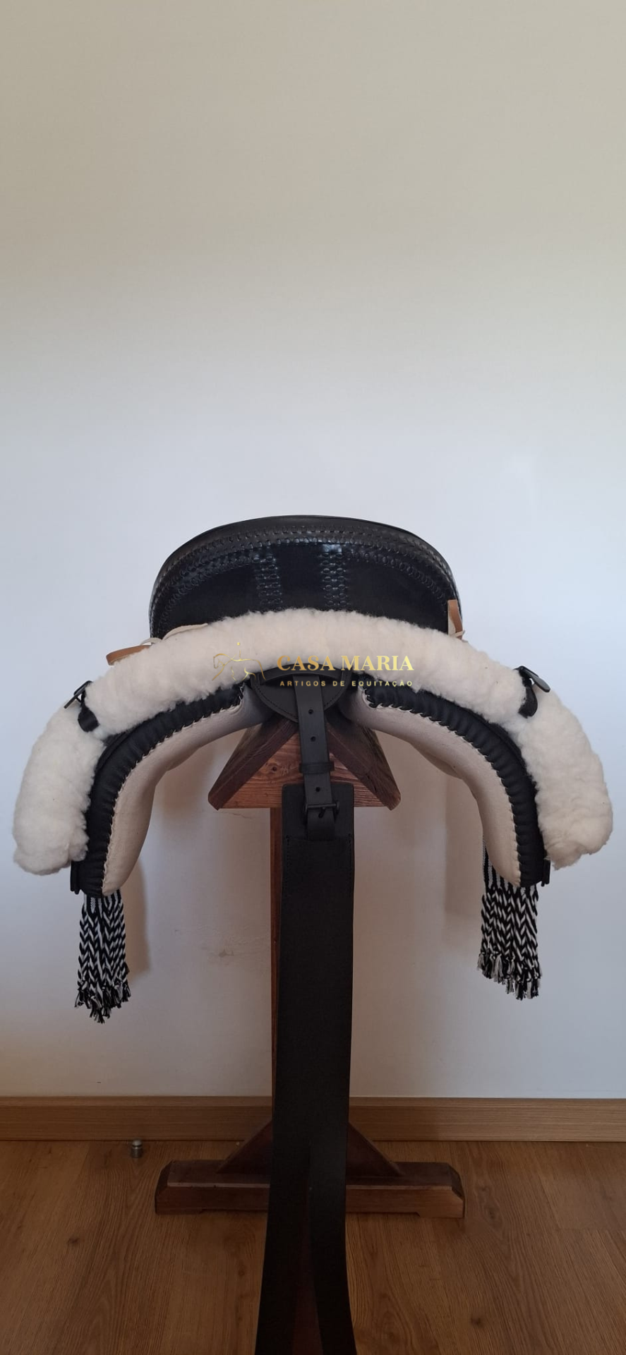 Selim de equitação com acolchoamento em lã branca e suporte de madeira