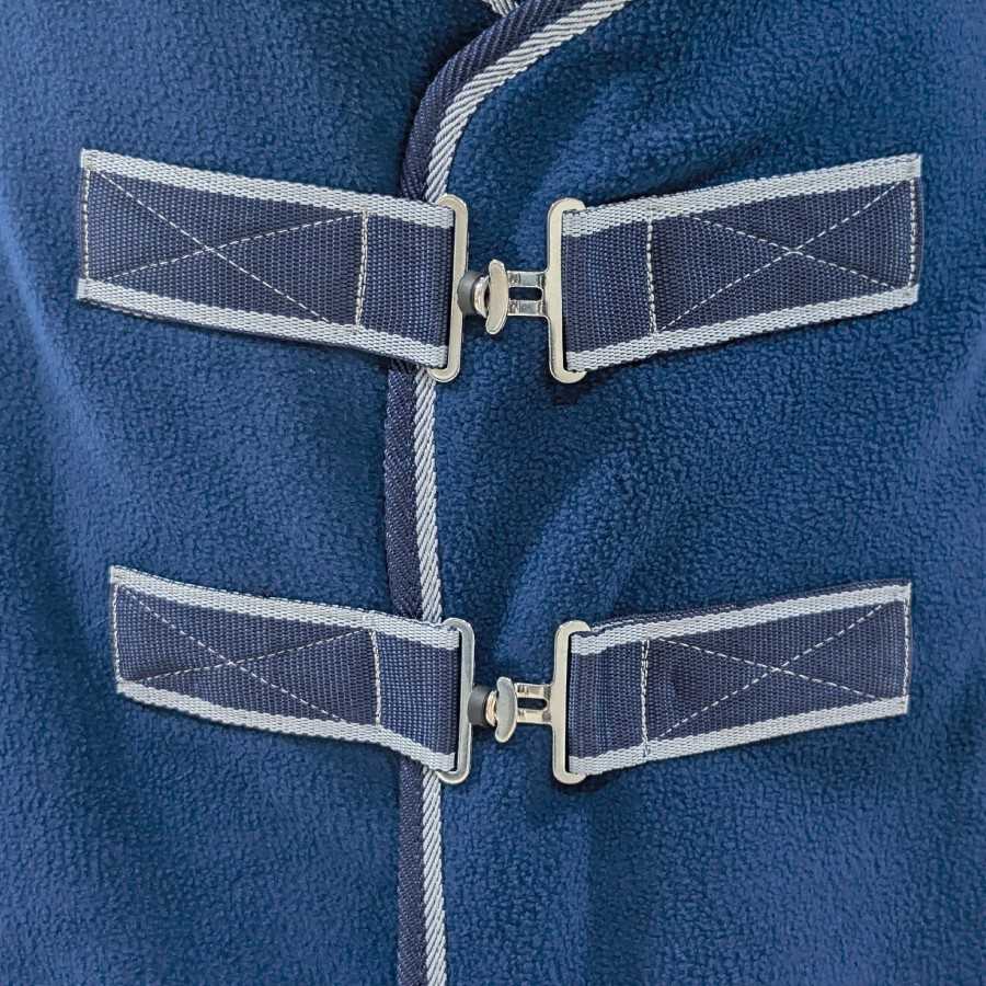 Fecho de roupa azul com faixa têxtil cinza e azul sobre tecido felpudo azul