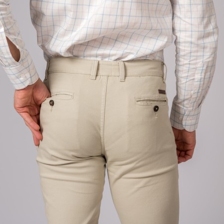 Calças bege com botões pretos e camisa branca xadrez azul