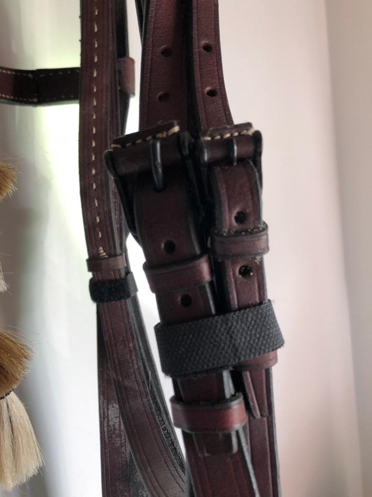 Correias de couro castanhas com fivelas metálicas em fundo branco