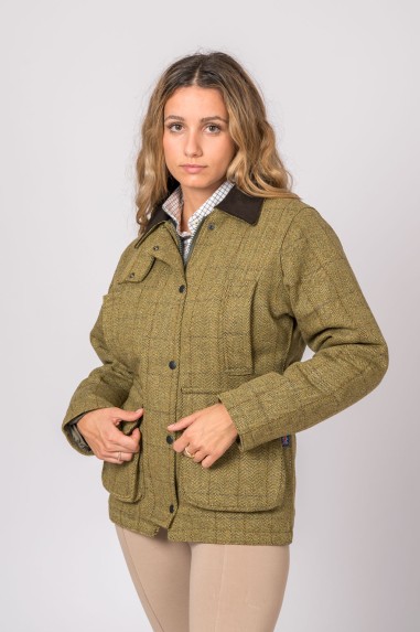 Mulher com casaco tweed verde musgo com padrão xadrez e gola castanha escura