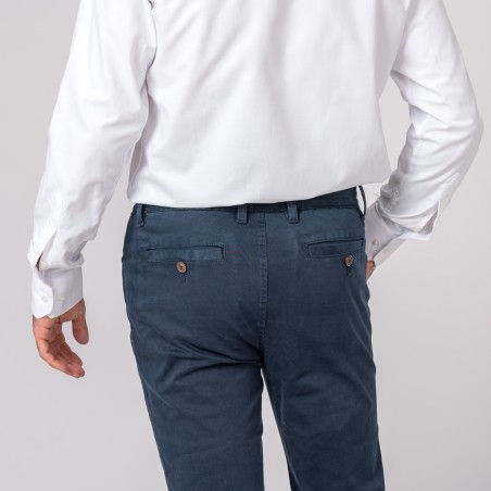 Calças azuis de algodão com bolsos de botão vistas por trás numa pessoa com camisa branca