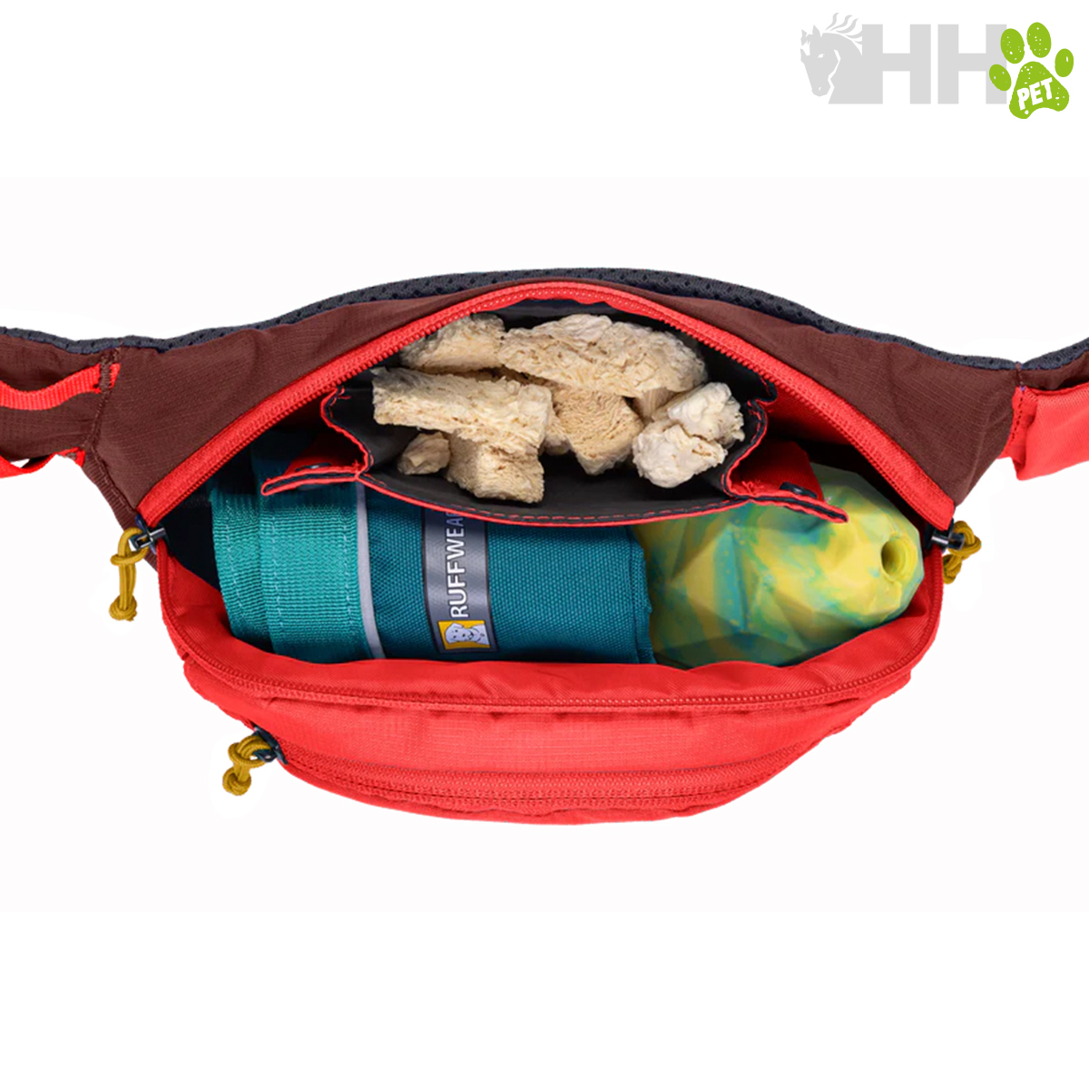 Bolsa de cintura vermelha aberta mostrando brinquedo azul, biscoitos para cães e saco plástico colorido