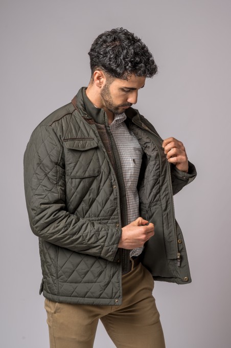 Casaco masculino verde-oliva acolchoado com padrão em losangos e gola castanha aberto por homem