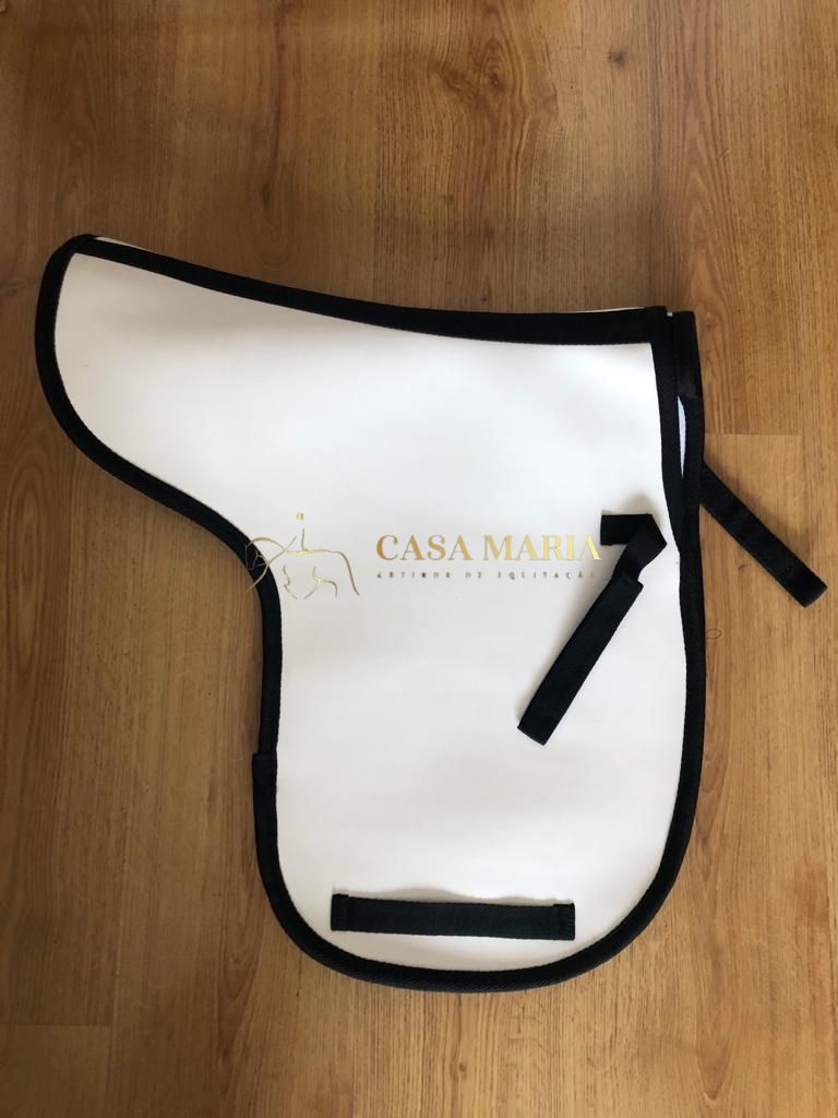 Protetor de sela branco com bordas pretas e texto dourado em chão de madeira