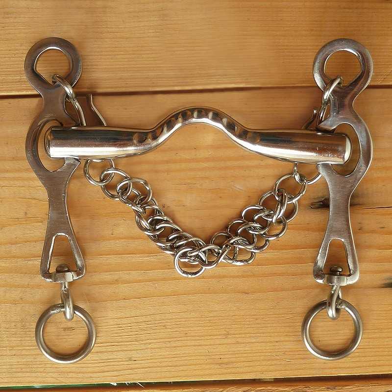 Freio de equitação metal prateado com corrente sobre madeira