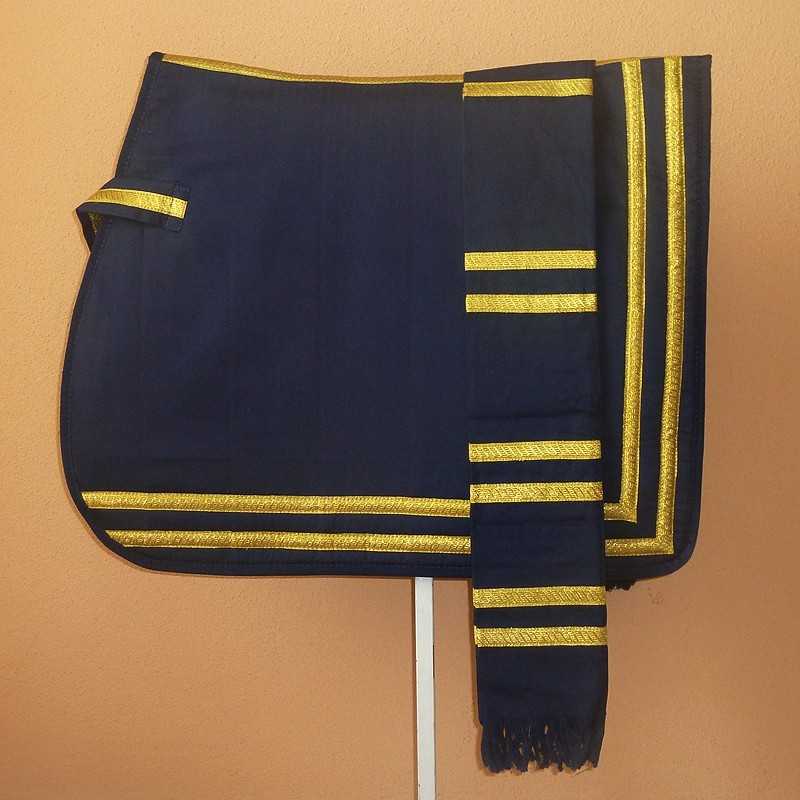 Manta ou capa azul escuro com riscas douradas pendurada numa parede cor de laranja