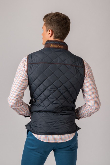 Homem de costas com colete preto acolchoado e camisa xadrez