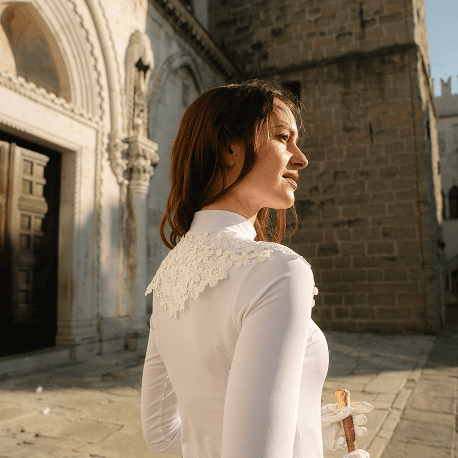 Blusa branca de manga comprida com detalhe de renda em cenário antigo