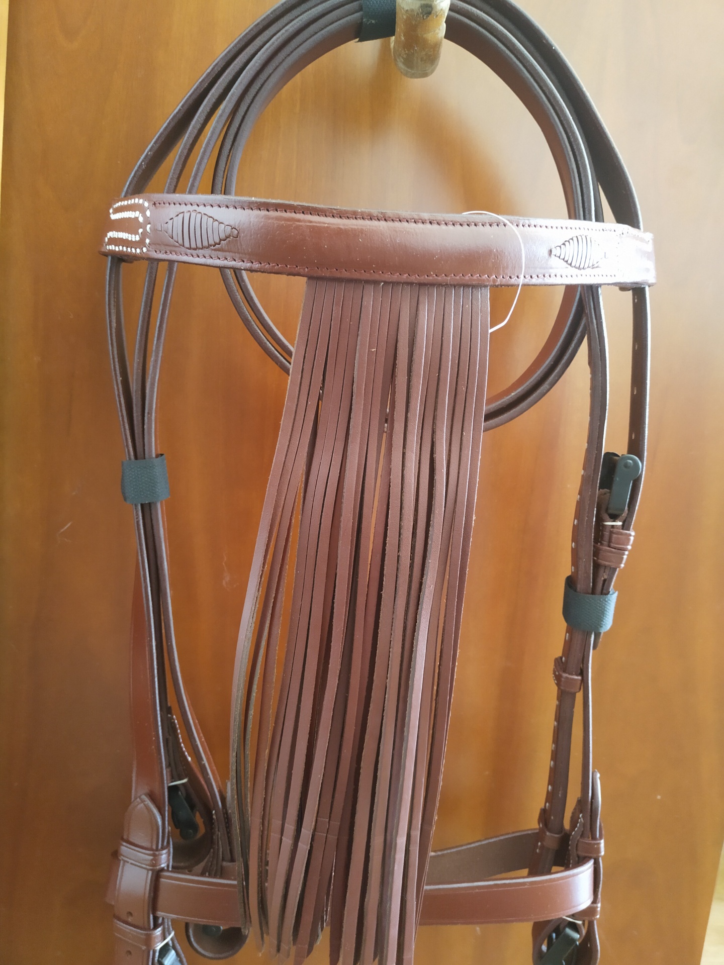 Cabresto de couro castanho com franjas pendurado