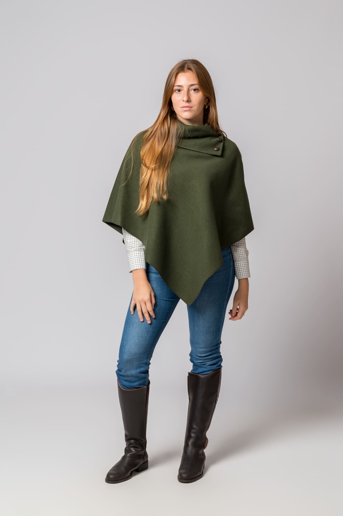 Mulher com capa poncho verde-oliva e botas pretas