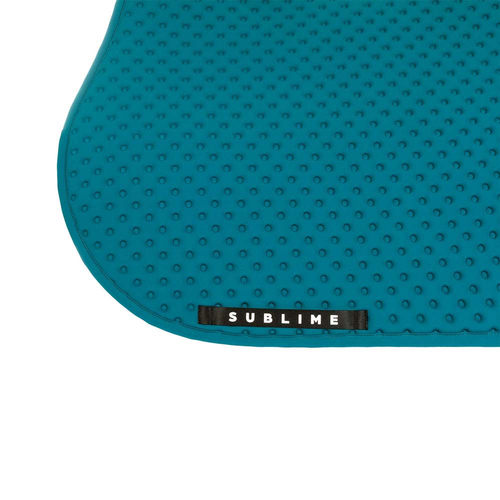 Detalhe de tapete antiderrapante azul com textura e etiqueta SUBLIME